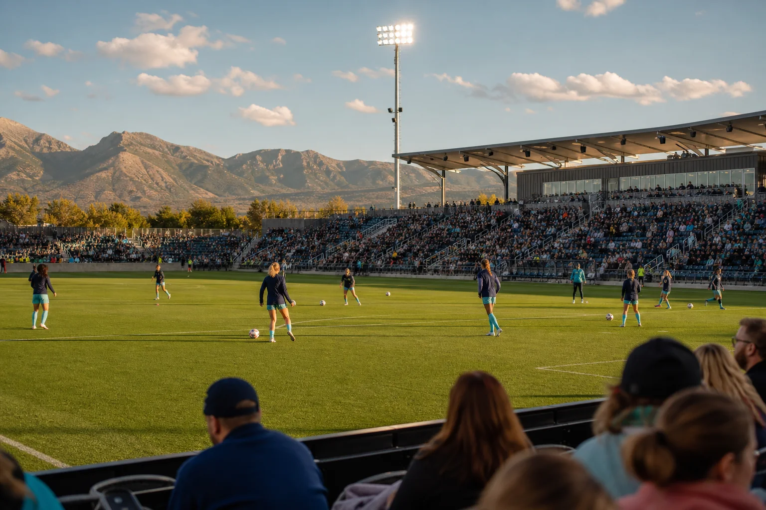 Women soccer players warming up in a compact Colorado stadium with mountain views